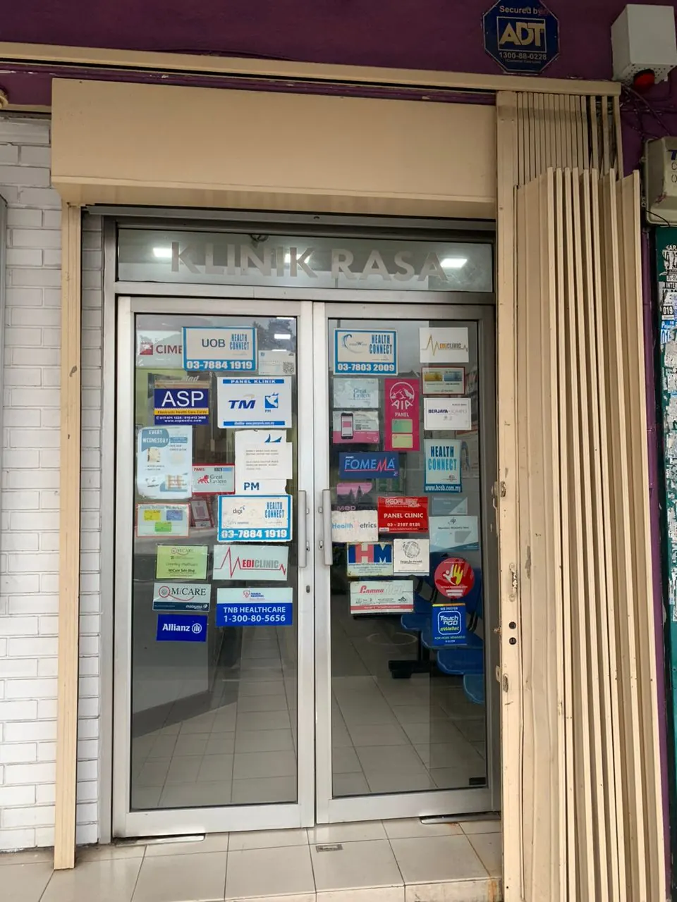 Klinik Rasa front door showing the insurance panel stickers