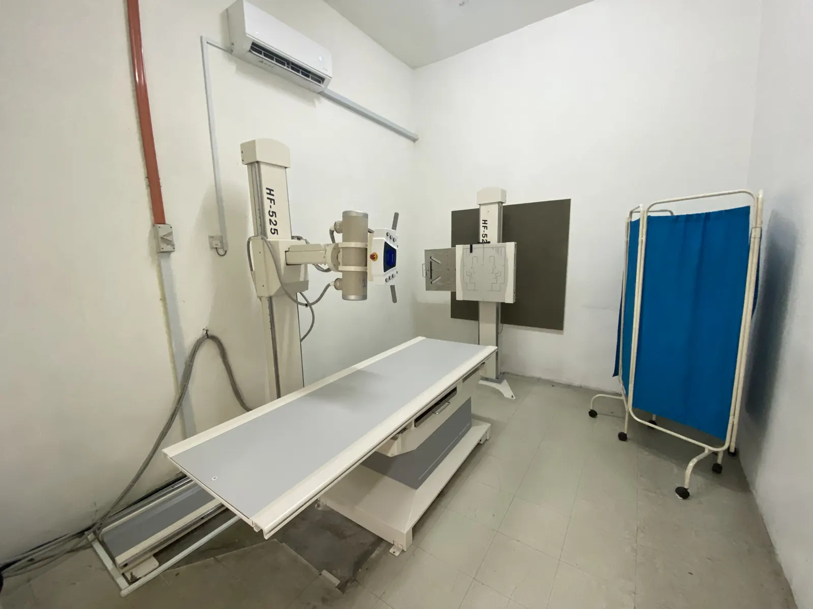 X-ray room at Klinik Rasa with the X-ray table, wall stand and privacy screen